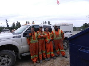 Four workers close to a truck