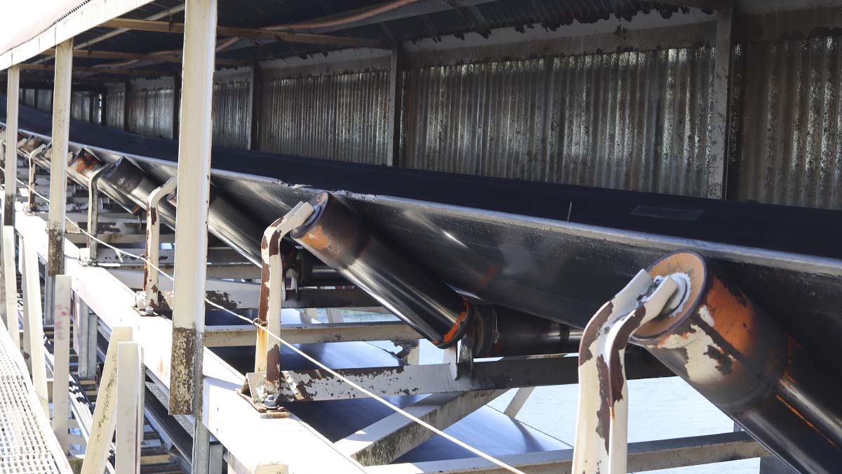 Conveyor trough idlers under a overhang