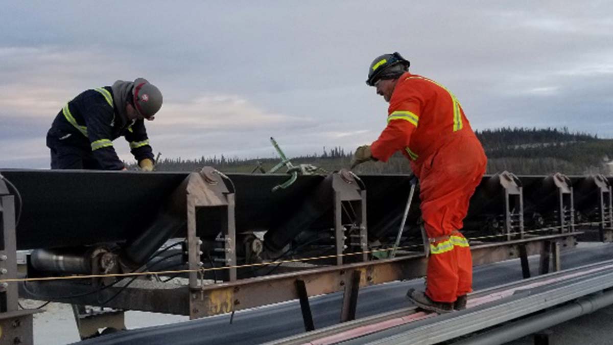 Two workers doing conveyor belt maintenance